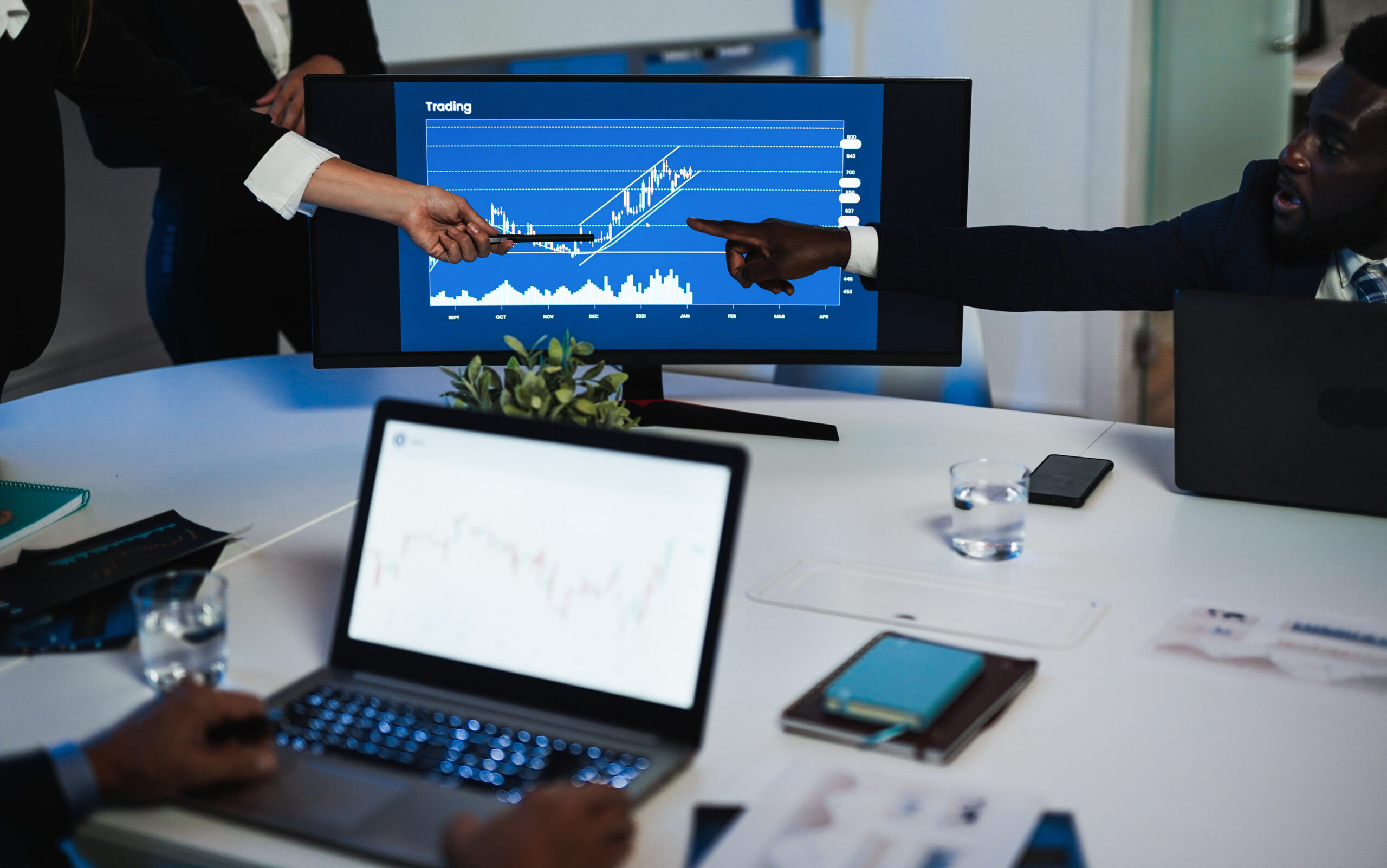 Multiracial traders team making stock market analysis inside hedge fund office - Bank teamwork discussing business strategies - Finance and trading concept - Focus on hands